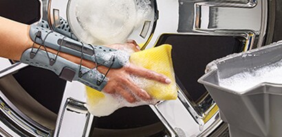 Washing car rims while wearing brace.
